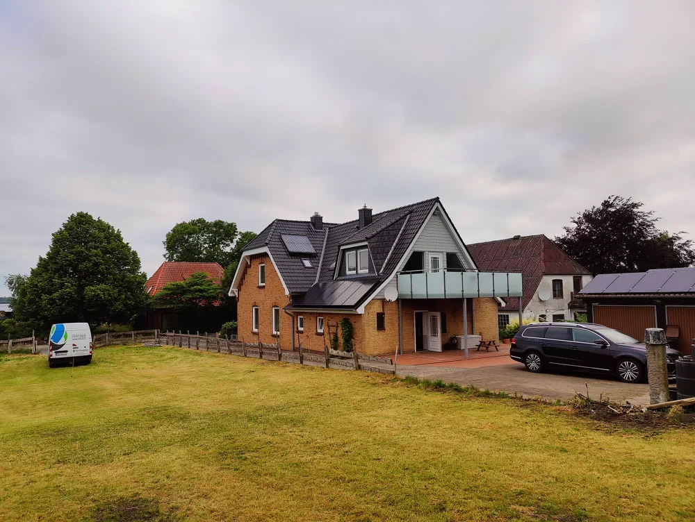 Wohnhaus mit Photovoltaikanlage und Servicefahrzeug